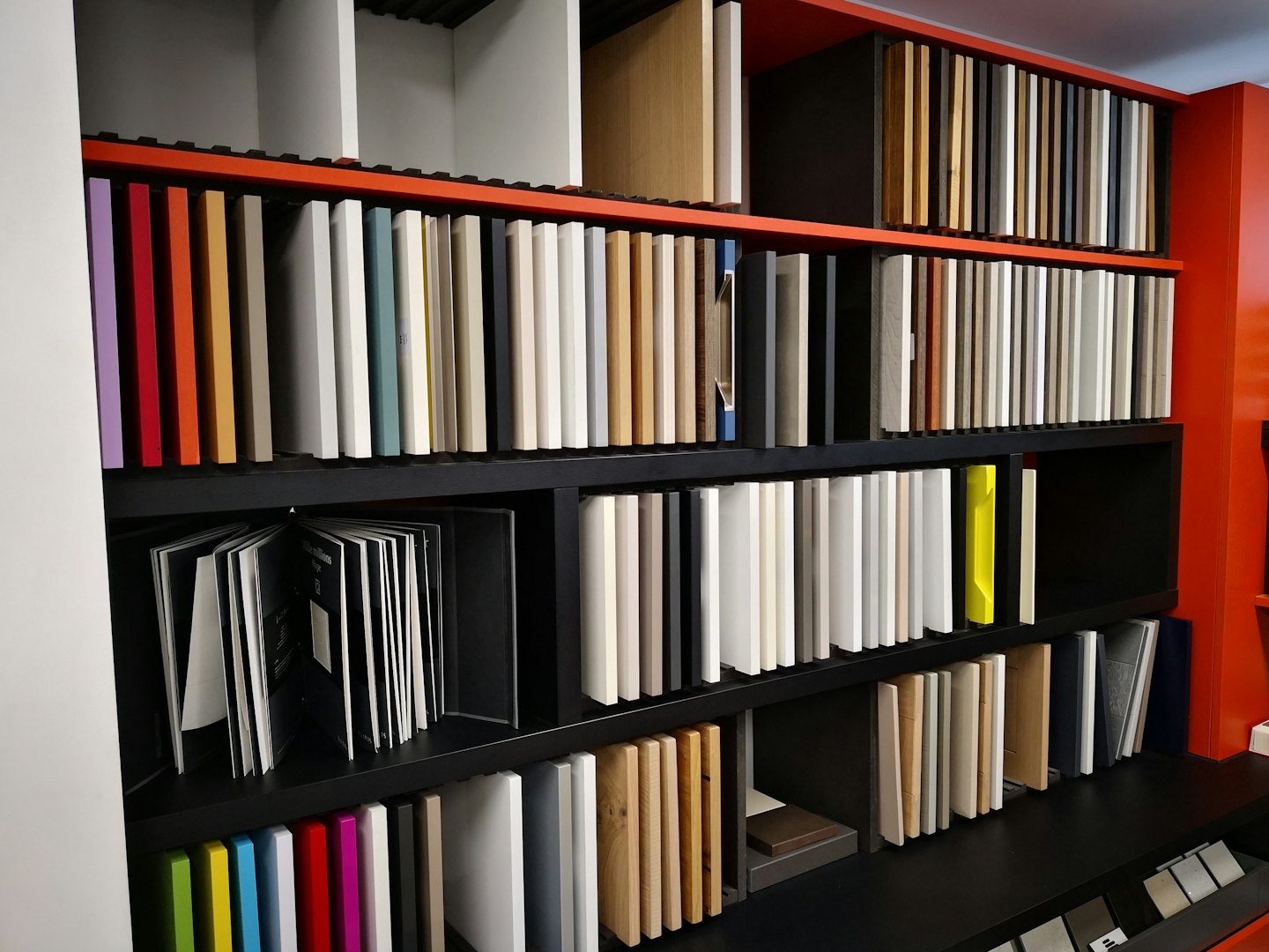 Material samples for cabinetry displayed on tiered shelving.