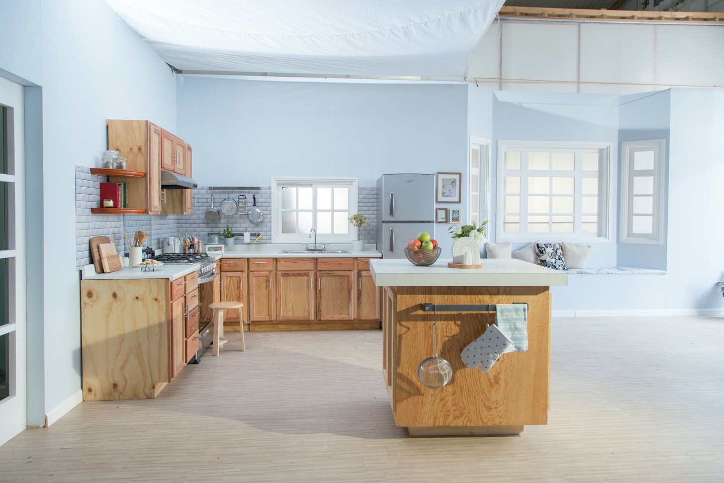 Modern kitchen with blue walls and wooden cabinets.