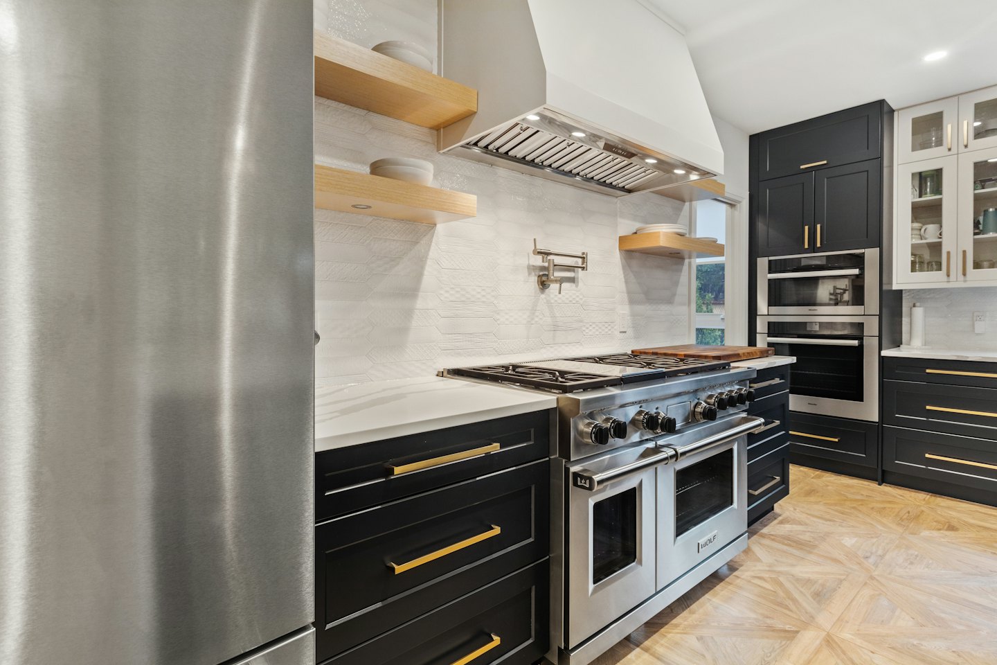 Modern kitchen with stainless steel appliances and black cabinetry.