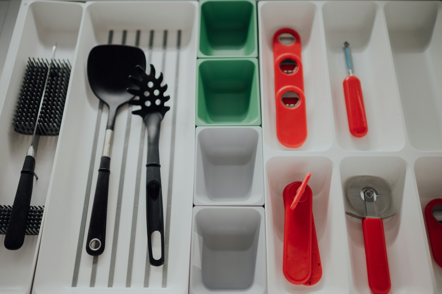 Kitchen utensils organized in a modular drawer storage system.